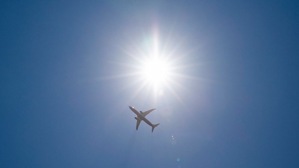 Flugzeug am Himmel vor strahlender Sonne (Quelle: IMAGO / Kirchner-Media)
