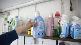 Verschiedene Waschmittel, Person greift zu einer Flasche (Quelle: IMAGO / photothek)