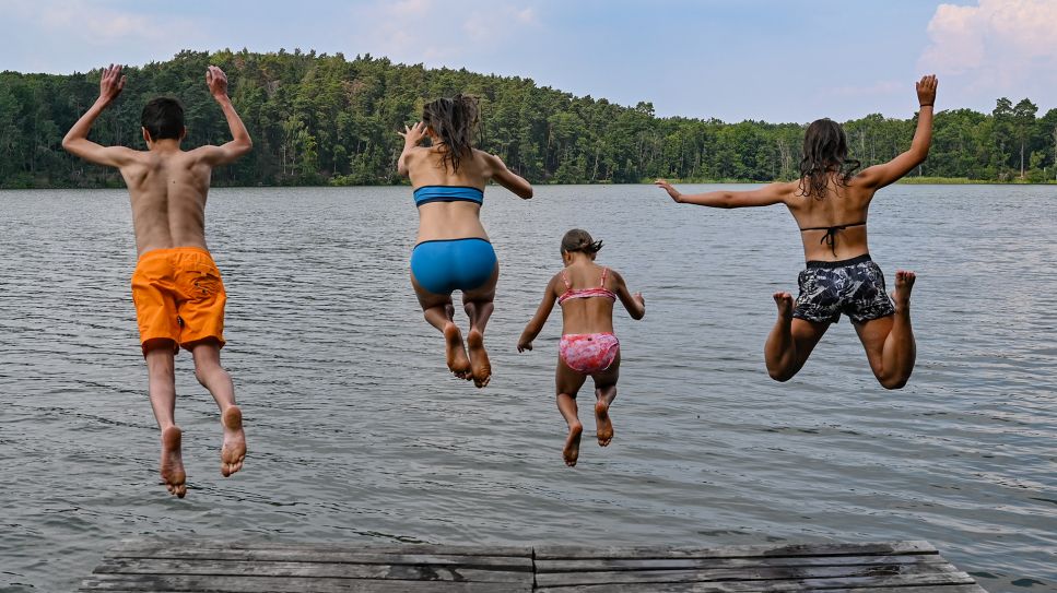 Vier Kinder springen von einem Steg in das Wasser des Trepliner Sees. Quelle: dpa-Zentralbild/ Patrick Pleul