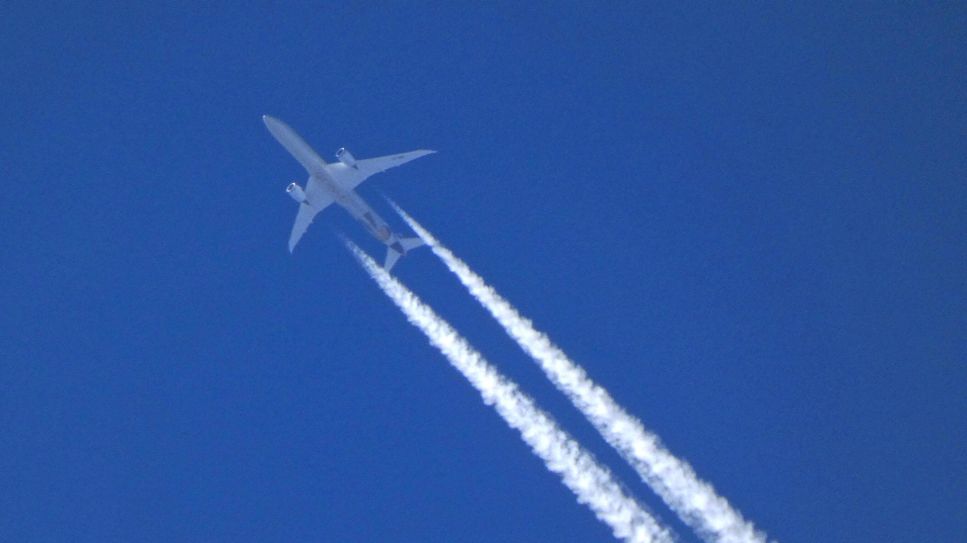 Flugzeug am blauen Himmel mit Kondensstreifen. Quelle: imago images/Martin Wagner