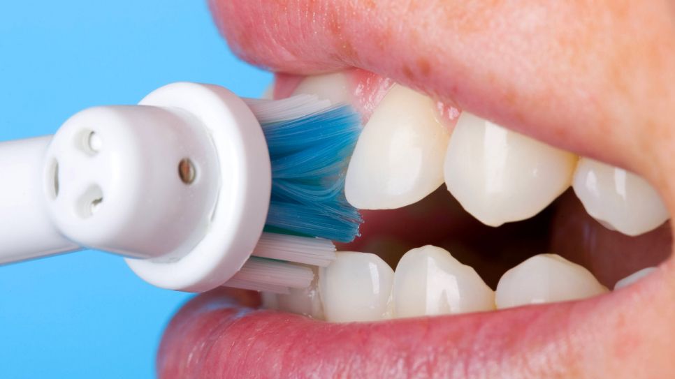 Eine elektrische Zahnbürste in einem Mund (Quelle: imago images / Shotshop)