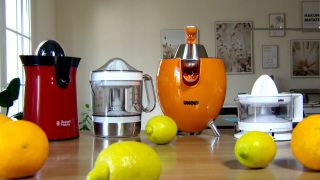 Vier Zitruspressen unterschiedlicher Hersteller auf einem mit Zitronen und Orangen dekoriertem Tisch (Quelle: rbb SUPER.MARKT)