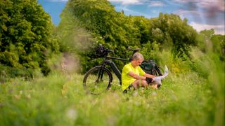 Ein Radler mit E-Bike in der Natur (Quelle: imago images / Westend61)