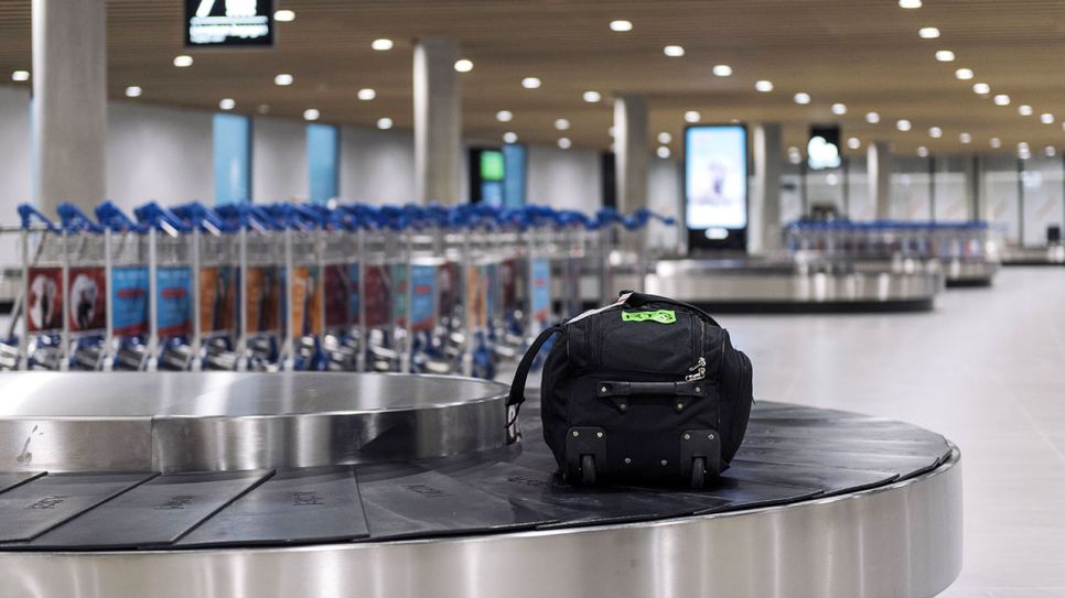 Eine Reisetasche liegt einsam auf einem Gepäckband eines Flughafens (Quelle: IMAGO / Andia)