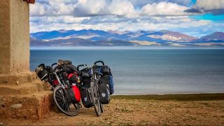 Schwer beladene Fahrräder an einem See (Quelle: imago images / Panthermedia)