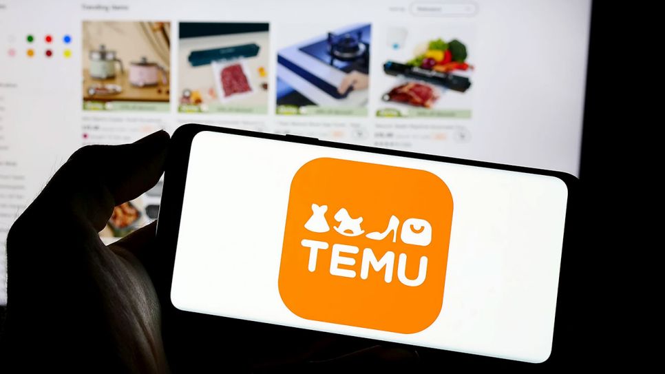 Das Logo der chinesischen Shopping-App Temu auf einem Smartphone, im Hintergrund auf einem Computerbildschirm die Benutzeroberfläche der Shoppingseite in einem Webbrowser (Quelle: IMAGO / Zoonar)