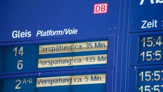 Informationstafel der Detuschen Bahn mit Verspätungen auf dem Hauptbahnhof Berlin (Quelle: IMAGO / Rolf Kremming)