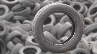 Viele Reifen auf einem Haufen, davor ein aufgestellter Reifen, der den Blick freigibt auf den haufen (Quelle: imago images/teutopress)