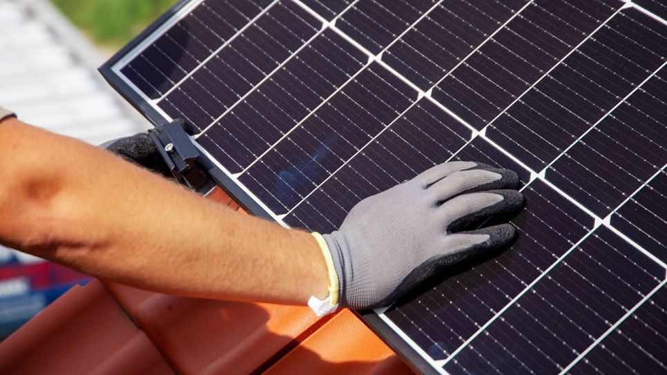 Eine Solarzelle wird auf einem Hausdach montiert (Quelle: IMAGO / Herrmann Agenturfotografie)
