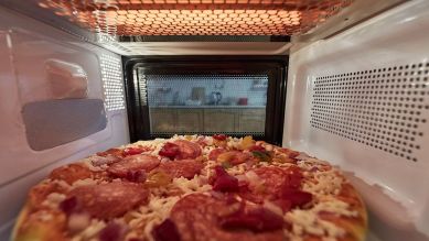 Eine Pizza in der Mikrowelle (Quelle: imago images/Panthermedia)