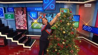 Moderatorin Janna Falkenstein steht im SUPER.MARKT-Studio und schmückt einen Weihnachtsbaum (Quelle: rbb)