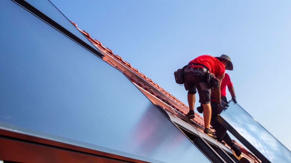 Solarpanele werden auf einem Dach befestigt (Quelle: imago images/Hermann Agenturfotografie)