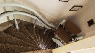 Ein Treppenlift im schmalen Treppenhaus (Quelle: imago images/Panthermedia)