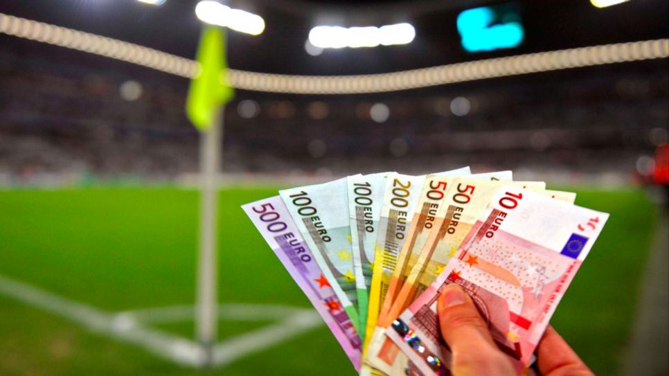 Jemand hält in einem Fußballstadion viele Euro-Scheine in die Kamera (Quelle: IMAGO / MIS)