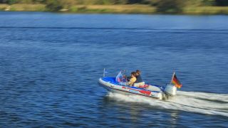 Ein Motorboot durchzieht einen Brandenburger See (Quelle: IMAGO/Rainer Weisflog)