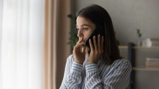 Telefonbetrug: Symbolbild zeigt junge Frau am Telefon mit besorgtem Blick (Quelle: colourbox)