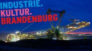 Braunkohletagebau Welzow-Süd, ein Schaufelradbagger im Vorschnitt; Schriftzug: "Industrie.Kultur.Brandenburg" (Quelle: rbb/picture alliance/Andreas Franke)