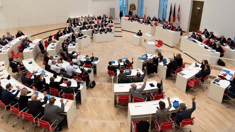 Abgeordnete nehmen im Brandenburger Landtag an einer Abstimmung per Handzeichen teil. (Quelle: dpa/Monika Skolimowska)