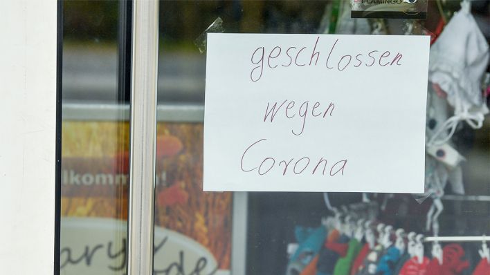 Symbolbild: Ein Zettel mit der Aufschrift "geschlossen wegen Corona" klebt an der Eingangstür zu einem Einzelhandelsgeschäft. (Quelle: dpa/Patrick Pleul)