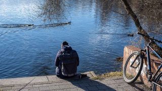 Junger Mann mit Kapuze an einem Ufer in Potsdam (Bild: imago images/Rolf Zöllner)