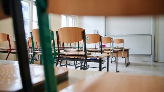 In einem Klassenzimmer des John-Lennon-Gymnasiums in Prenzlauer Berg stehen am 11.01.2021 die Stühle auf den Tischen. (Quelle: dpa/Annette Riedl)