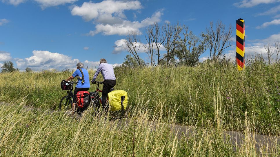 Radwandertouristen fahren mit ihren bepackten Fahrrädern auf dem Oder-Neiße-Radweg, der sich im Oderbruch befindet. (Quelle: dpa/Patrick Pleul)