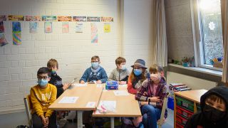 Schüler und Schülerinnen sitzenl zusammen an einem Tisch und tragen dabei einen Mund-Nasen-Schutz. (Quelle: dpa/Gregor Fischer)
