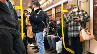 Menschen fahren in Zeiten der Coronapandemie mit FFP2-Masken U-Bahn und schauen auf ihre Mobiltelefone. (Quelle: imago images/Sabine Brose)