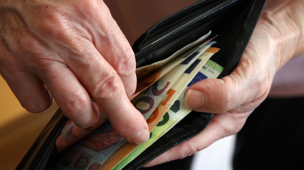 Symbolbild: Eine Hand zieht Geldscheine aus einem Geldbeute (Quelle: pa/Eibner-Pressefoto)