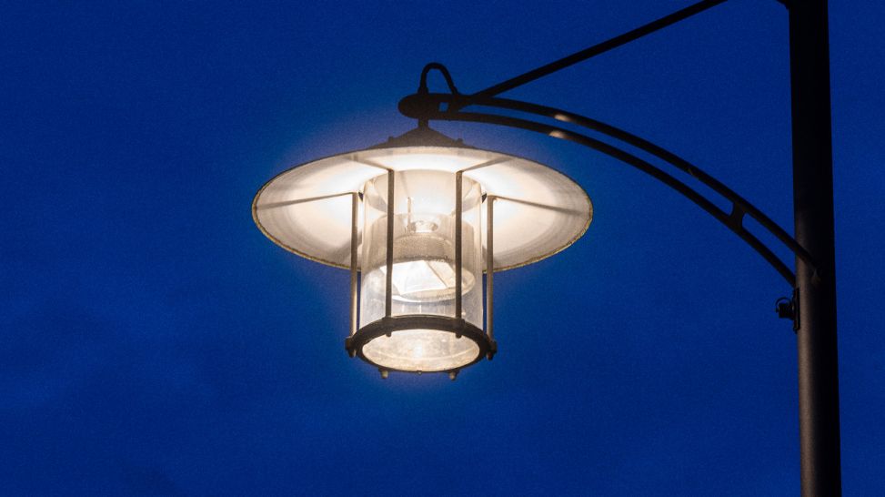 Symbolbild: Eine Laterne leuchtet bei Nacht (Bild: dpa/Michael Reichel)