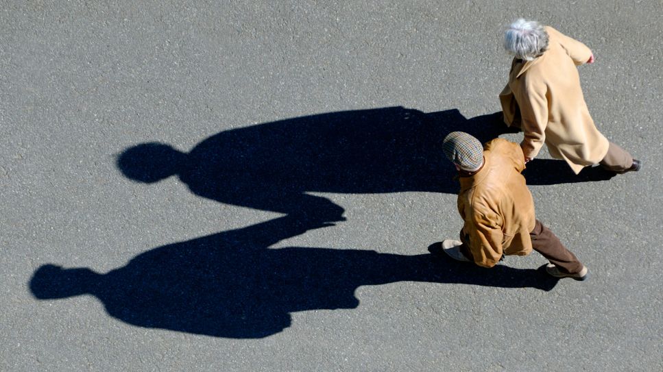 Archivfoto: Älteres Ehepaar in Deutschland geht am 14.10.2007 Hand in Hand spazieren, Aufnahme aus der Vogelperspektive mit Schattenwurf (Quelle: dpa / imageBROKER / Michael Dietrich).