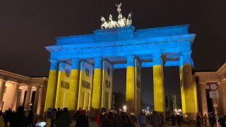 Am Jahrestag des russischen Überfalls auf die Ukraine wird in Berlin das Brandenburger Tor in den Farben der ukrainischen Nationalflagge angestrahlt. (Quelle: rbb/Helena Daehler)