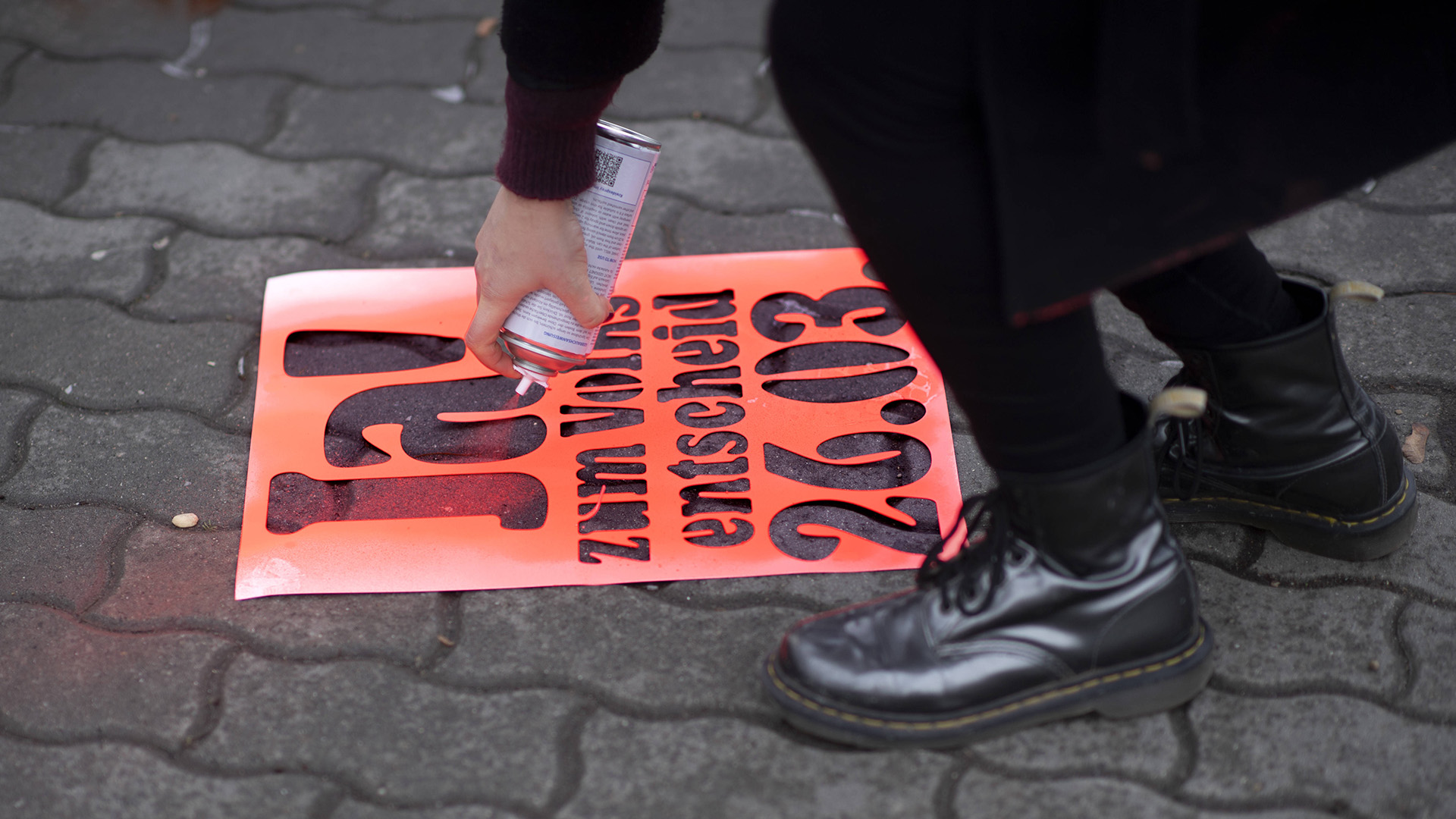 Symbolbild:Eine Person sprüht mithilfe einer Schablone:"Ja!zum Volksentscheid 26.03." auf die Straße.(Quelle:imago images/IPON)