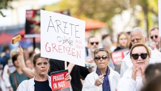 Ärzte gehen bei dem Protestmarsch „Ärzte in Not“ mit Schildern mit der Aufschrift „Ärzte an den Grenzen“ durch Berlin Mitte. (Quelle: dpa/F. Sommer)