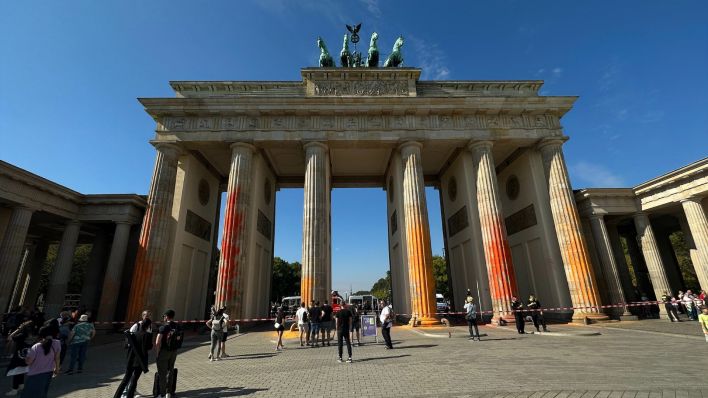 Klimaaktivisten besprühen Brandenburger Tor mit orangener Farbe. (Quelle: rbb)