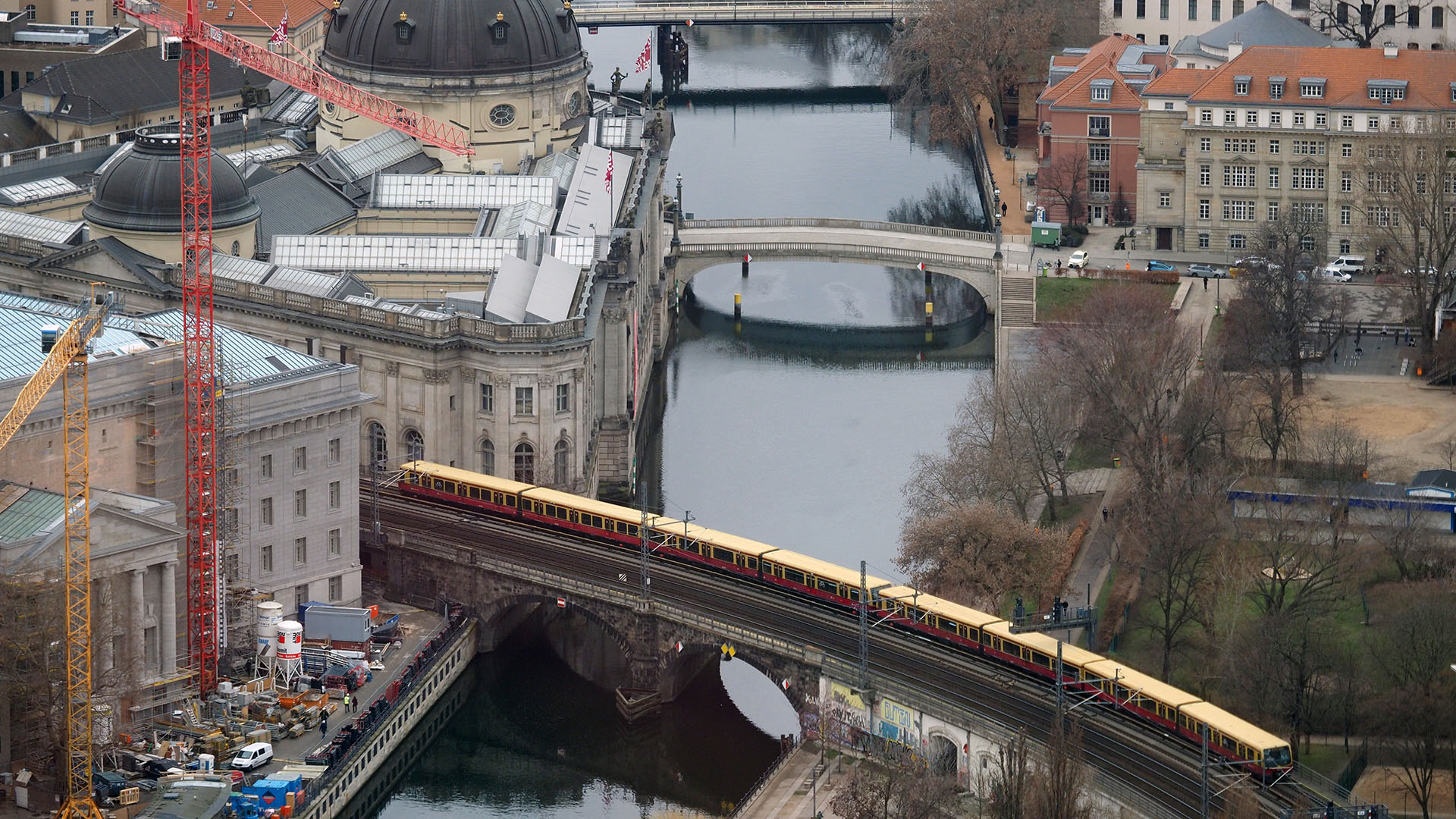 Archivbild: Blick aus dem Fernsehturm am Alexanderplatz auf die Innenstadt mit der Spree an der Museumsinsel, dem Bodemuseum (l), eine über die Brücke fahrenden S-Bahn und dem Monbijoupark (Quelle: dpa / Sören Stache).