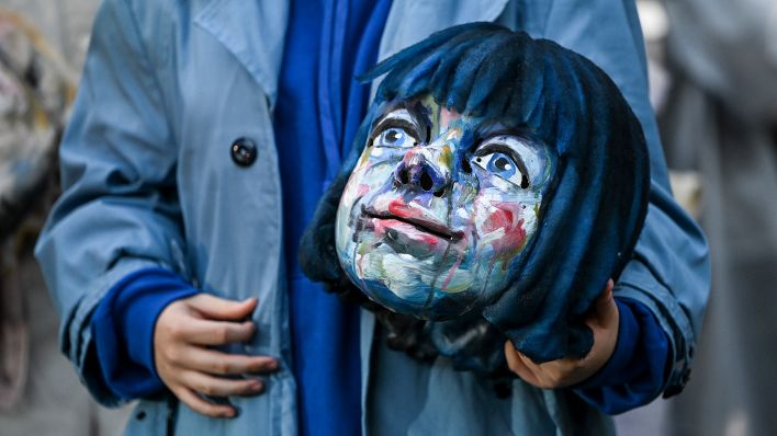 Archivbild:Eine Darstellerin hält ihre Maske der Momo vor einer Probe des Stücks "Momo“ beim Theatersommer Netzeband in den Händen am01.08.2023.(Quelle:picture alliance/dpa/J.Kalaene)