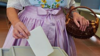 Symbolbild:Eine Wählerin in in sorbisch-wendischer Tracht wirft ihren Wahlbrief in die Urne.(Quelle:picture alliance/dpa-Zentralbild/P.Pleul)