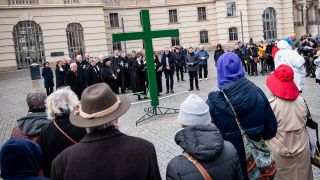 Gläubigenehmen an der Karfreitagsprozession der St. Marienkirche mit einem grünen Kreuz am Bebelplatz teil. (Foto: dpa)