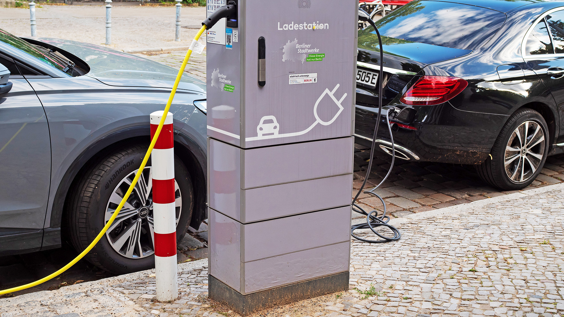 Symbolbild:Zwei Elektroautos - ein Audi und ein Mercedes - stehen zum Laden der Batterien an einer Ladestation der Berliner Stadtwerke im Stadtteil Lichterfelde am 28.06.2023. (Quelle:picture alliance/dpa/Wolfram Steinberg)