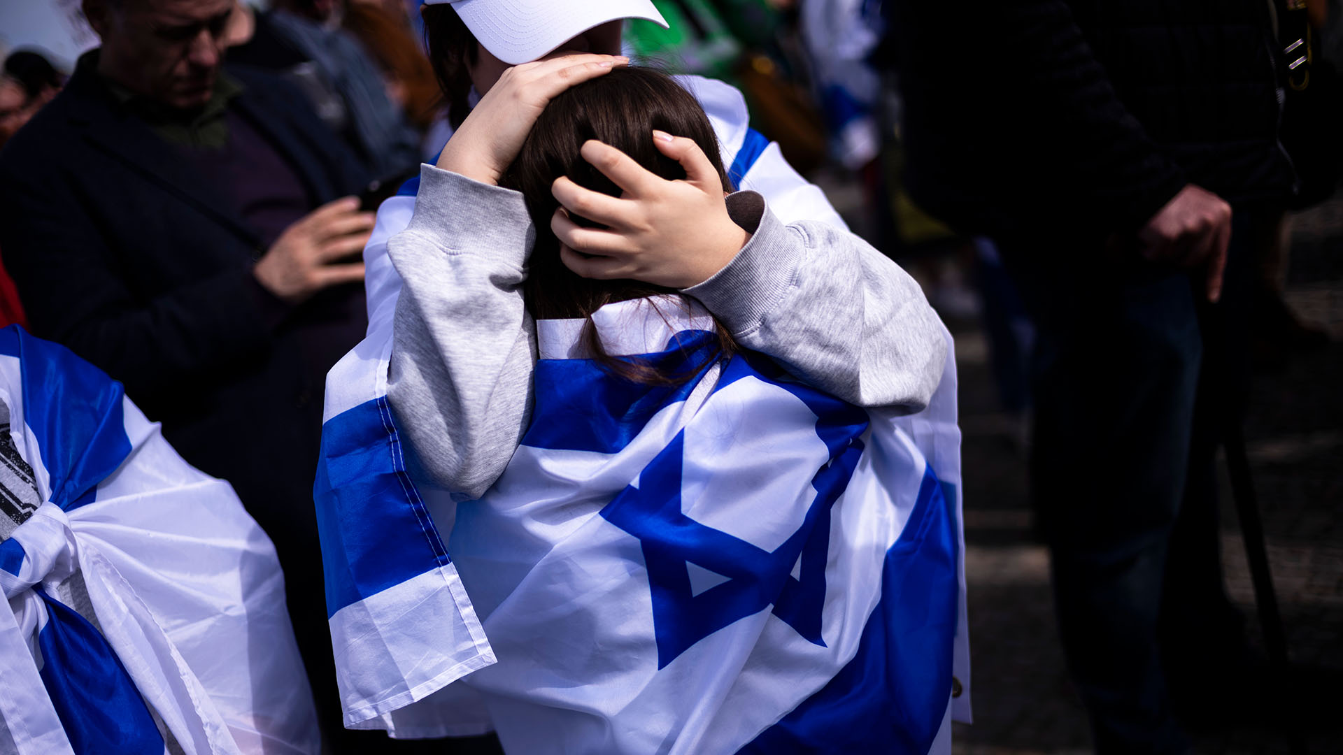 Eine Frau umarmt ein Kind mit einer israelischen Flagge während einer Solidaritäts-Demonstration mit Israel am Brandenburger Tor in Berlin. (Quelle: dpa/AP/Markus Schreiber)