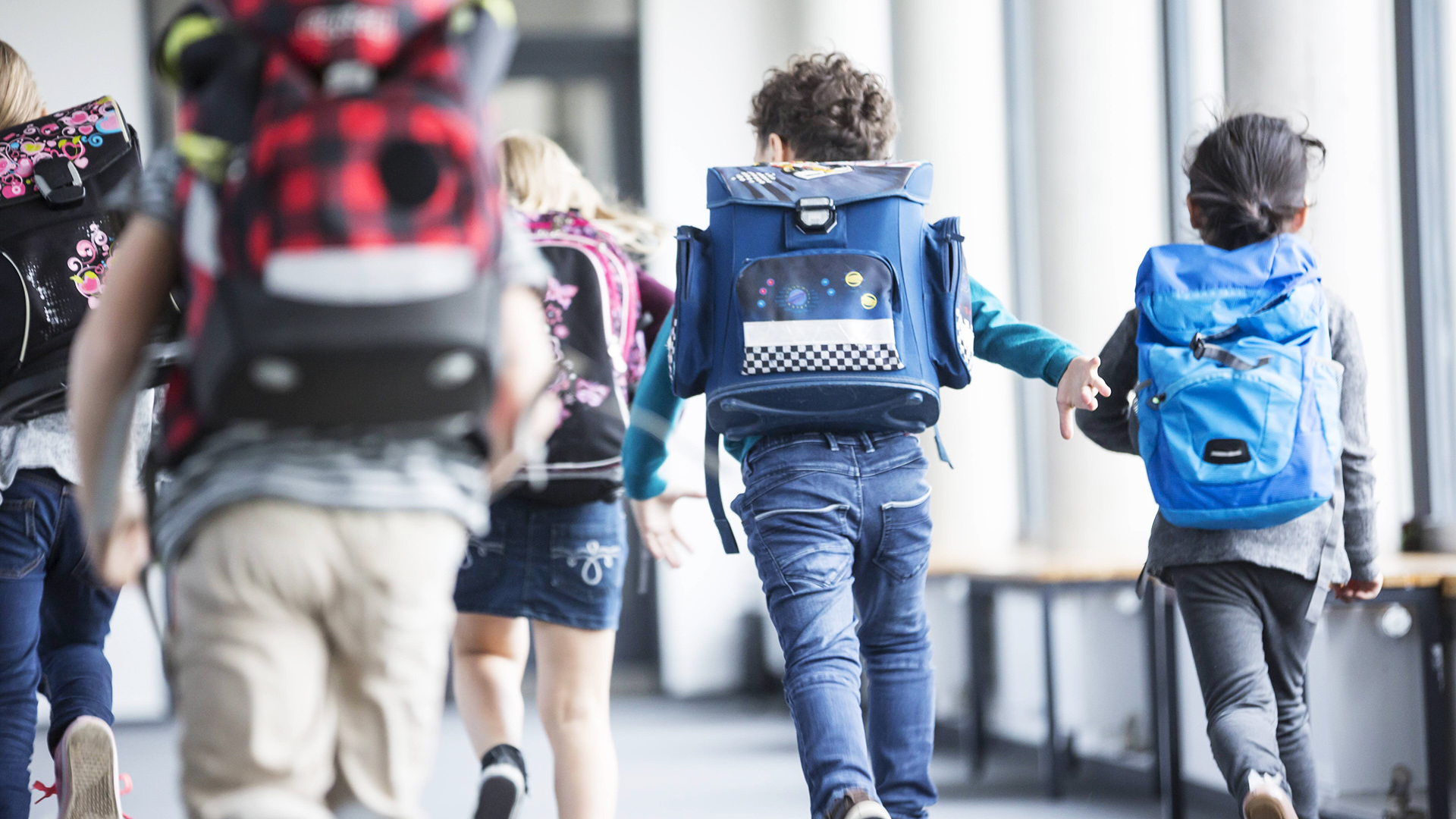 Symbolbild: Schulkinder rennen den Korridor entlang.(Quelle: IMAGO)