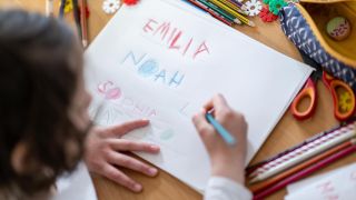 Symbolbild: Ein Mädchen schreibt die Vornamen Noah, Emilia, Sophia und Mattheo auf ein Blatt. (Quelle: dpa-Bildfunk/Hendrik Schmidt)