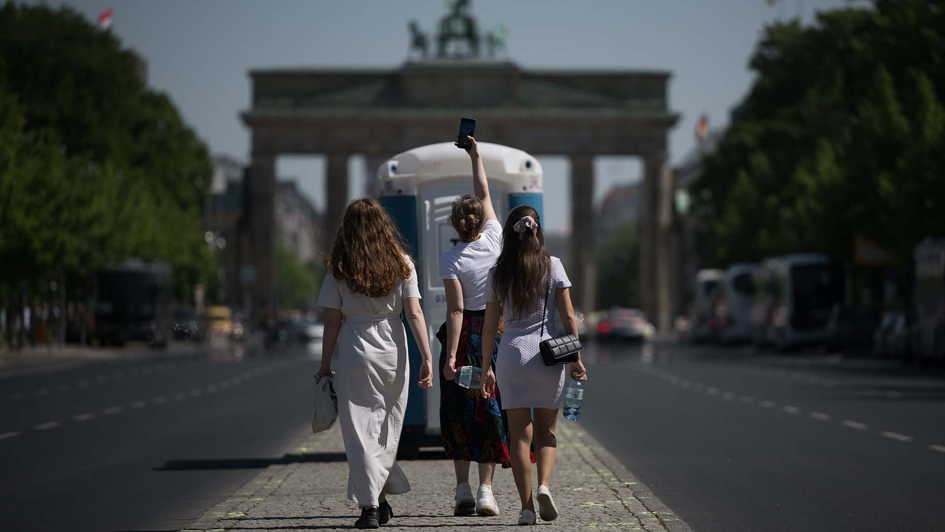 Symbolbild: Eine Frau macht vor ihren Freundinnen, mit denen sie Urlaub in Berlin macht, ein Foto auf der gesperrten Straße des 17. Juni. (Quelle: dpa/Gollnow)