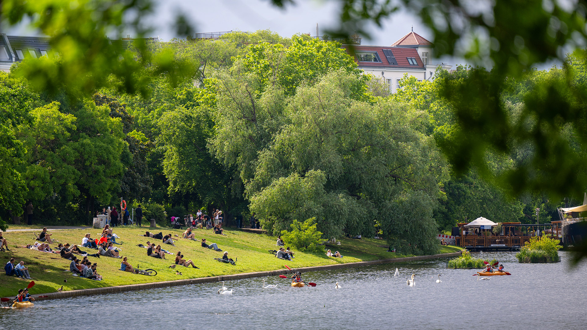 Zahlreiche Menschen sitzen beim sonnigen Wetter im Mai am Landwehrkanalufer. (Quelle: dpa/Monika Skolimowska)