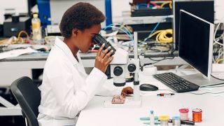 Symbolbild:Eine Wissenschaftlerin arbeitet in einem Labor an einem Mikroskop.(Quelle:picture alliance/Zoonar/Max)