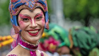 Eine Tänzerin der Gruppe "Sapucaiu No Samba" lächelt am 19.05.2024 vor der Parade zum 26. Karneval der Kulturen. (Quelle: dpa-Bildfunk/Monika Skolimowska)