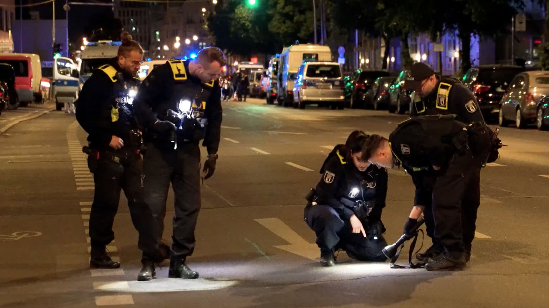 Polizisten suchen nach einem Tötungsdelikt in einem Park in Berlin-Gesundbrunnen auf einer Straße nach Spuren. (Quelle: dpa/Michael Ukas)