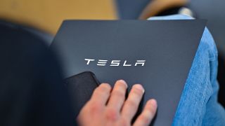 Ein Mitarbeiter vom US-Elektroautobauer Tesla sitzt mit einer Aktenmappe bei der Abstimmung am 16.05.2024.(Quelle:dpa/P.Pleul)