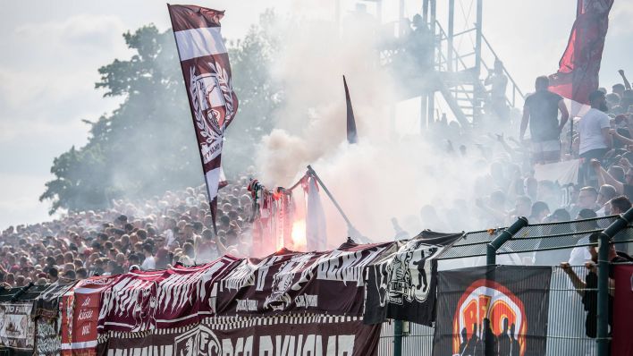 Anhänger des BFC Dynamo präsentieren Fan-Utensilien von Energie Cottbus und zünden diese an (imago images/Beautiful Sports)